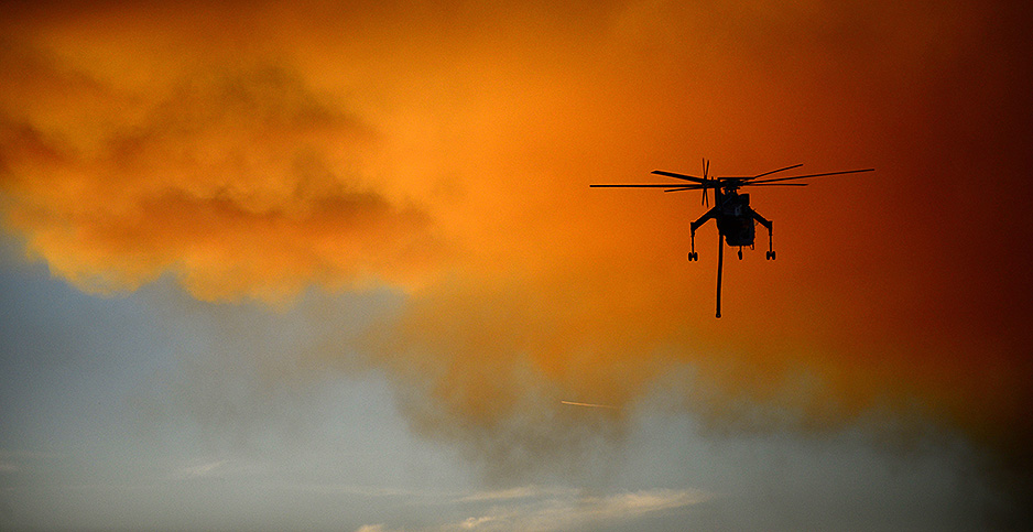 A helicopter crew helps fight a wildfire near Yosemite National Park in December. Photo credit: Nano Calvo/Newscom