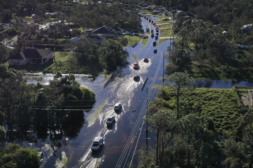 Vehicles drive through standing water after Hurricane Ian pulverized Port Charlotte, Fla.