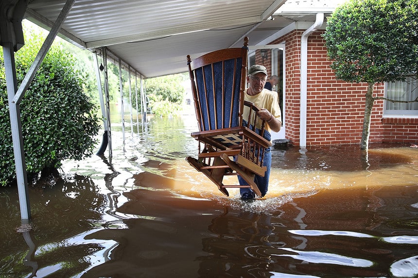 A man salvages items from a flooded house in North Carolina.